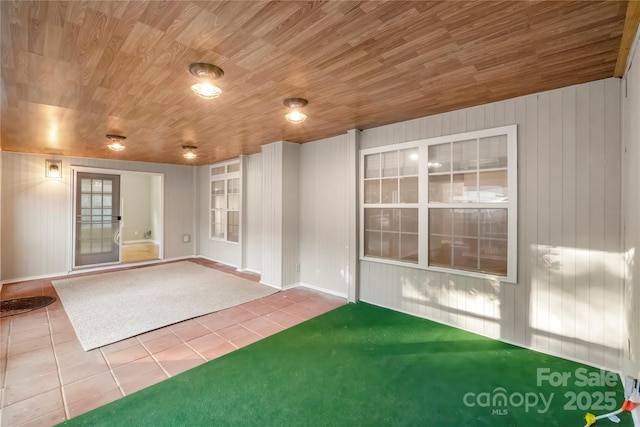 tiled spare room featuring wood ceiling