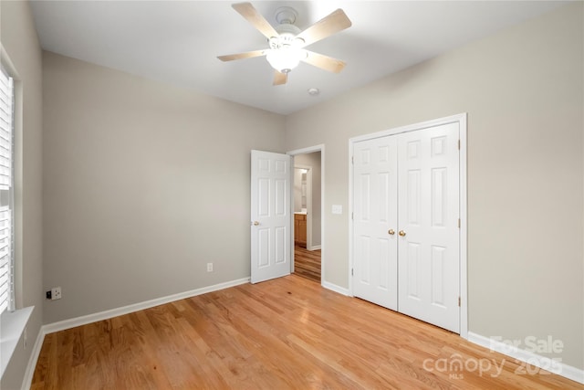 unfurnished bedroom featuring light wood-style floors, ceiling fan, baseboards, and a closet