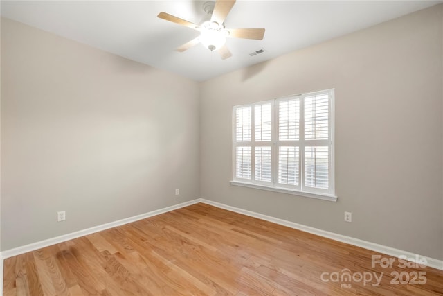 unfurnished room featuring ceiling fan, light wood-type flooring, visible vents, and baseboards