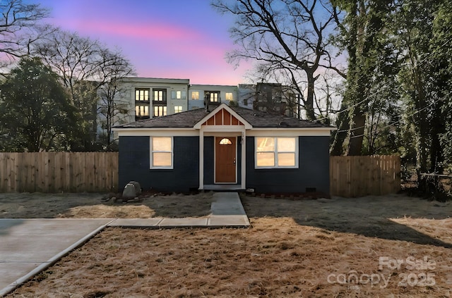 bungalow-style home with fence