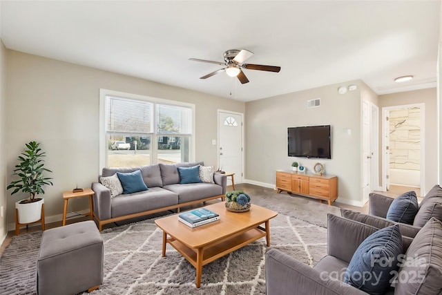 living room with visible vents, a ceiling fan, and baseboards