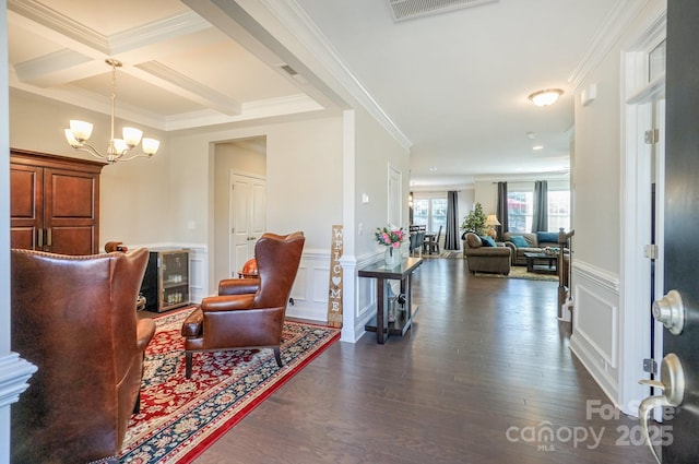 entryway with a decorative wall, dark wood-type flooring, ornamental molding, coffered ceiling, and beamed ceiling