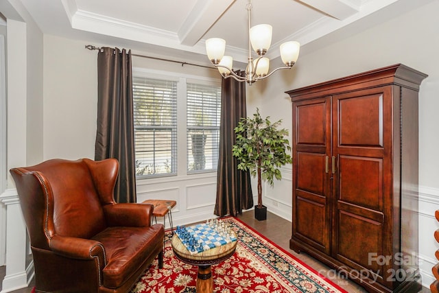 sitting room with beam ceiling, a decorative wall, ornamental molding, wood finished floors, and a chandelier