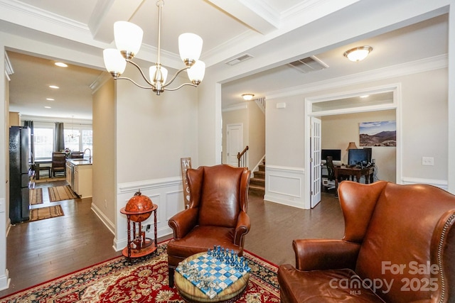 living area with ornamental molding, visible vents, and an inviting chandelier