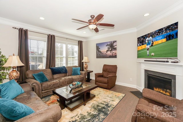 living area featuring recessed lighting, a fireplace with flush hearth, ornamental molding, wood finished floors, and baseboards