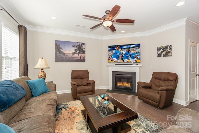 living room with crown molding, visible vents, a fireplace with flush hearth, dark wood-type flooring, and baseboards