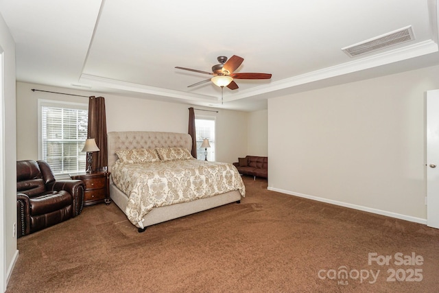 carpeted bedroom with ornamental molding, a tray ceiling, visible vents, and baseboards