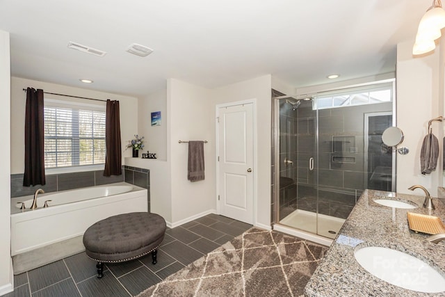 bathroom featuring visible vents, a sink, a shower stall, and double vanity