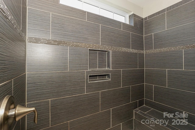 interior details featuring a tile shower