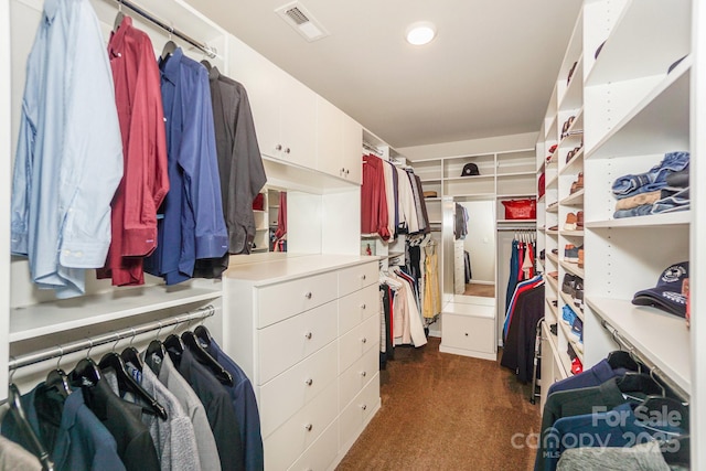 walk in closet with visible vents and dark colored carpet