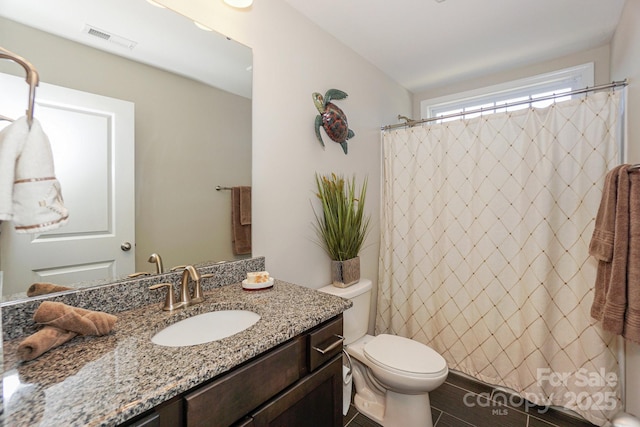 bathroom featuring toilet, visible vents, and vanity