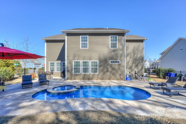 back of property featuring a pool with connected hot tub, fence, central AC, and a patio