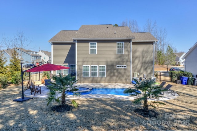 rear view of house featuring a patio area, a hot tub, fence, and a fenced in pool