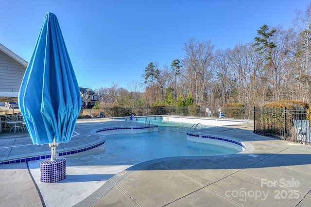 community pool featuring fence and a patio