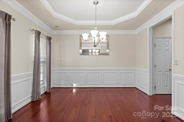 unfurnished dining area with dark wood-style floors, a tray ceiling, visible vents, and an inviting chandelier