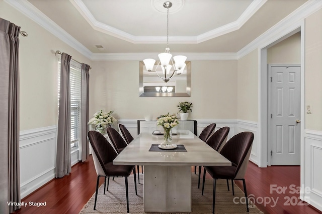 dining area featuring visible vents, a raised ceiling, wainscoting, dark wood-style flooring, and an inviting chandelier