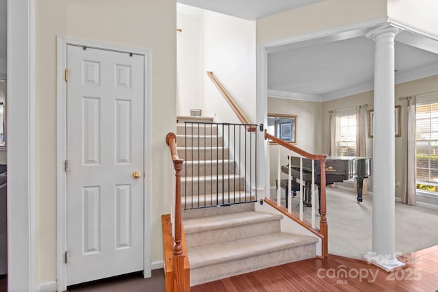 stairway featuring ornamental molding, decorative columns, and baseboards