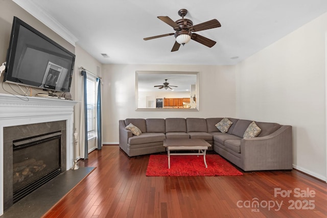 living area featuring visible vents, hardwood / wood-style floors, a high end fireplace, ceiling fan, and baseboards