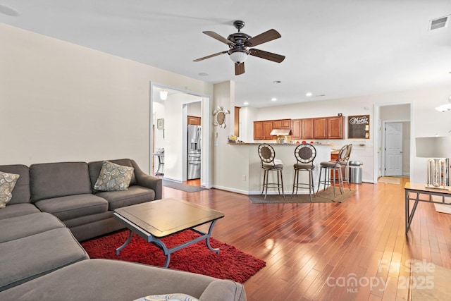 living area featuring recessed lighting, visible vents, baseboards, a ceiling fan, and wood-type flooring