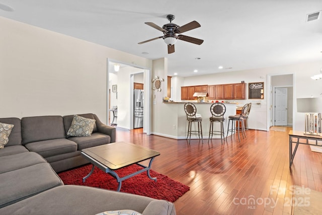 living area with recessed lighting, visible vents, a ceiling fan, baseboards, and hardwood / wood-style flooring