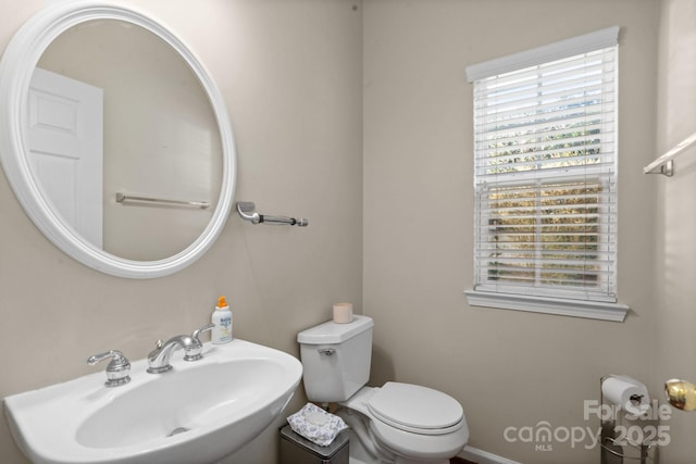 half bathroom featuring a sink and toilet