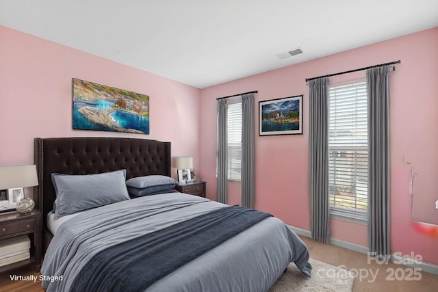 carpeted bedroom with visible vents and baseboards