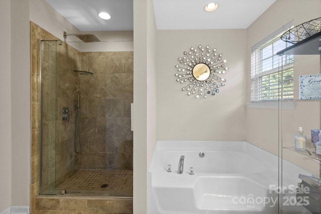 bathroom featuring a stall shower, a bath, and recessed lighting