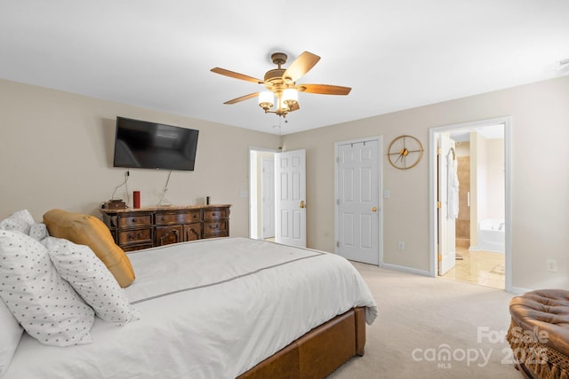 bedroom featuring light carpet, ceiling fan, connected bathroom, and baseboards