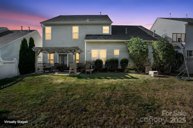 back of property at dusk with a patio area, fence, a pergola, and a lawn