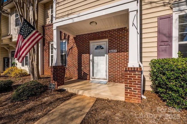 entrance to property featuring brick siding