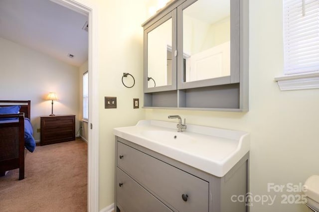 bathroom with vaulted ceiling, vanity, and toilet