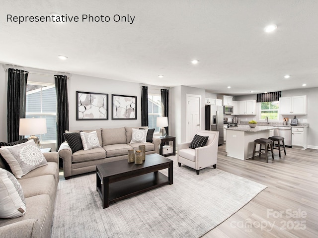 living area with recessed lighting and light wood finished floors