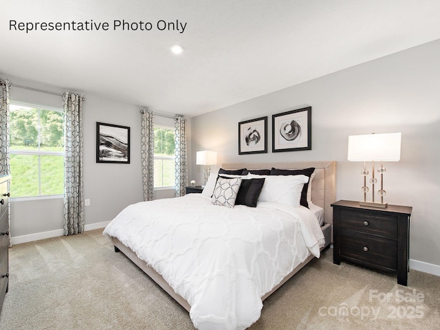 bedroom with light carpet and baseboards