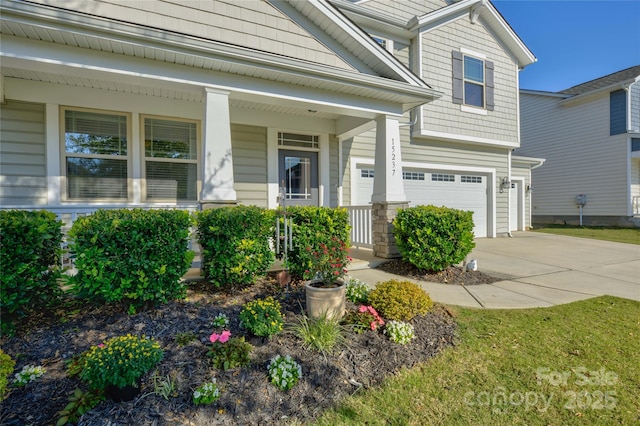 view of front of property with covered porch, concrete driveway, and an attached garage