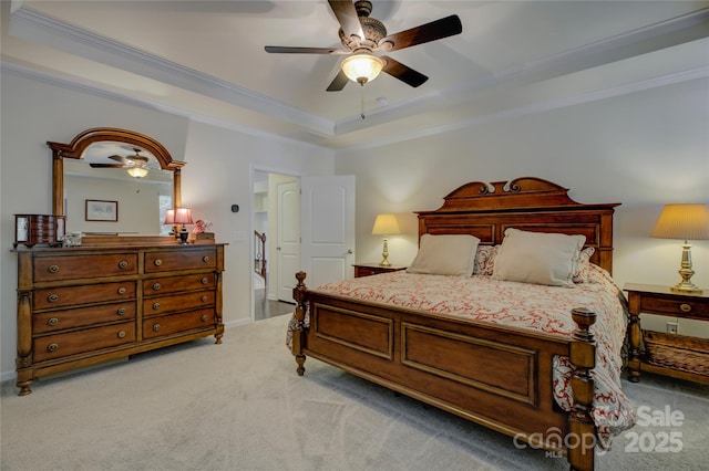 bedroom featuring light carpet, a tray ceiling, a ceiling fan, and ornamental molding