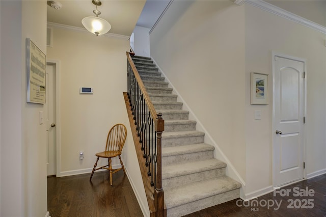 staircase with crown molding, baseboards, and wood finished floors