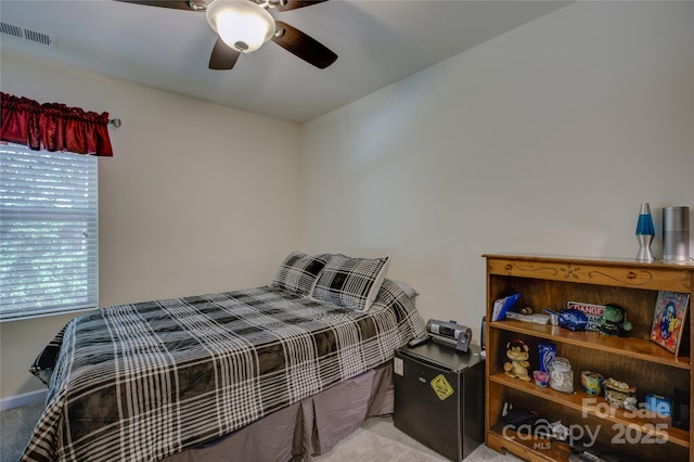 bedroom with a ceiling fan, light colored carpet, visible vents, and baseboards