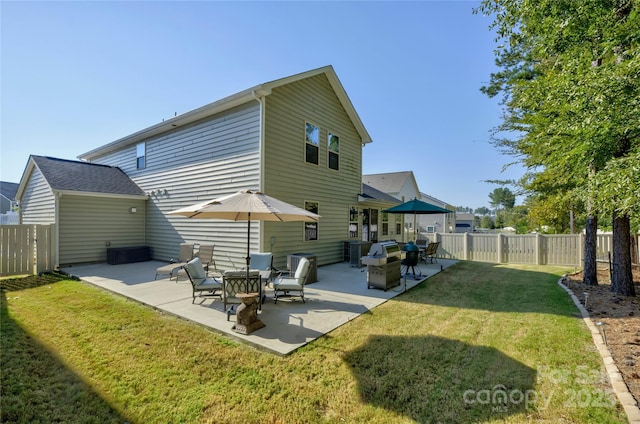 back of property featuring a patio, a lawn, and a fenced backyard