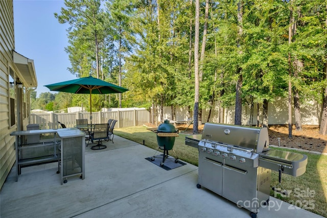 view of patio featuring a grill, a fenced backyard, and outdoor dining space