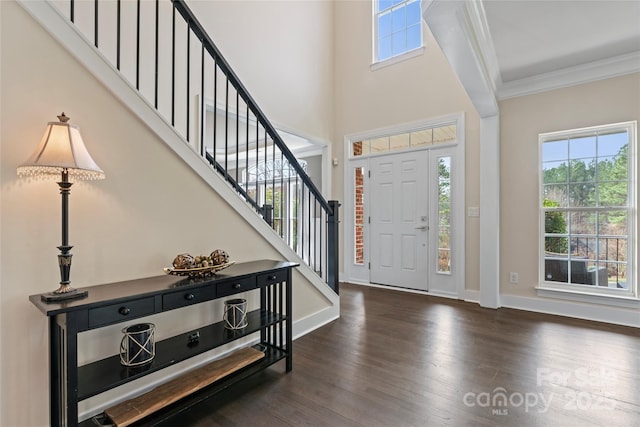 foyer entrance featuring crown molding, stairway, baseboards, and wood finished floors