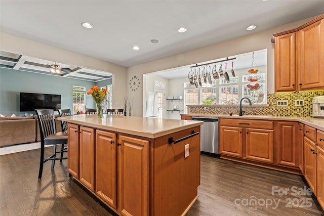 kitchen with dark wood-style flooring, backsplash, a kitchen island, a sink, and dishwasher