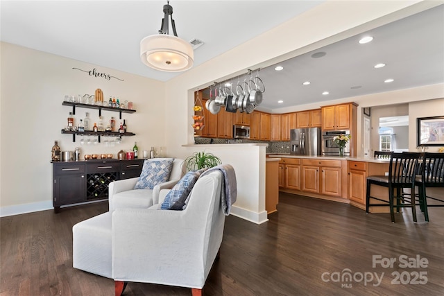 living room with recessed lighting, visible vents, baseboards, dark wood-style floors, and a dry bar