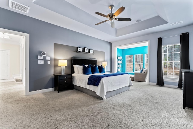 bedroom with carpet, a raised ceiling, visible vents, and baseboards