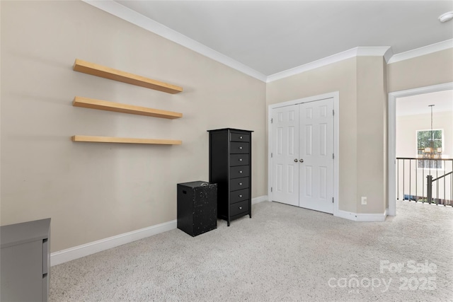 carpeted bedroom featuring a closet, crown molding, and baseboards