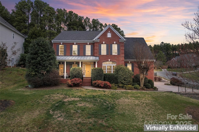 view of front of home featuring a front yard and brick siding