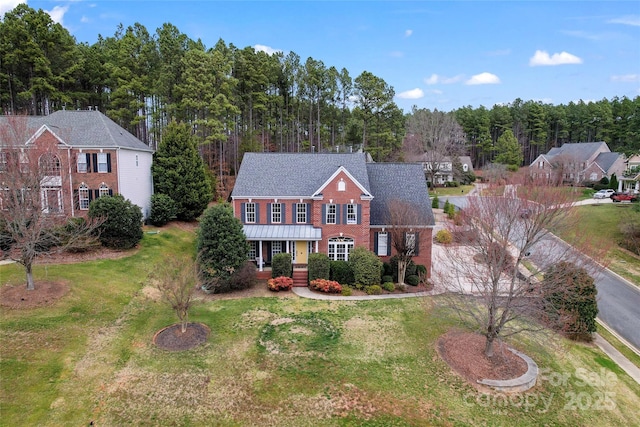 view of front of house featuring a shingled roof, brick siding, and a front lawn