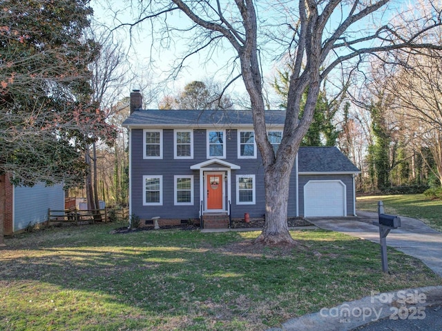 colonial inspired home featuring a garage, driveway, a chimney, and a front lawn