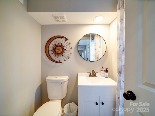 bathroom featuring visible vents, vanity, and toilet