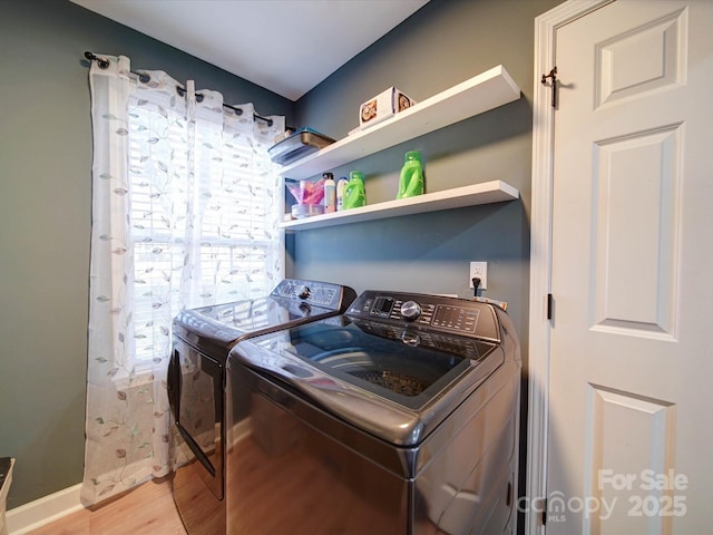 laundry area with laundry area, light wood-style flooring, and washing machine and clothes dryer