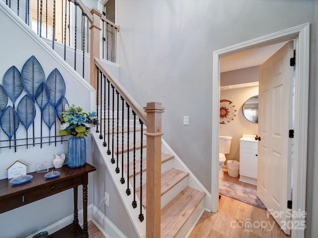 stairway featuring baseboards and wood finished floors